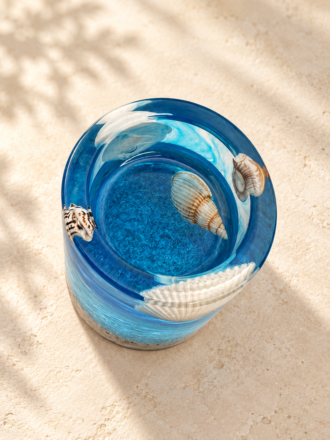 Angled top view of a blue resin candle holder with pale shell details and a glossy rim, handmade in Lancashire UK by Held Forever Studio