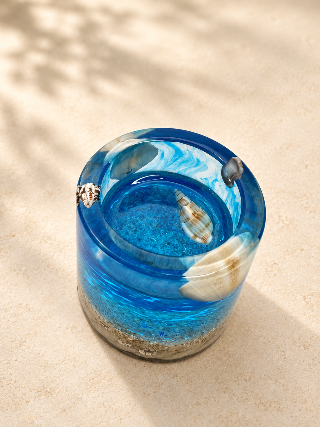Close view of a blue resin candle holder showing layered colour and shell details, handmade in Lancashire UK by Held Forever Studio