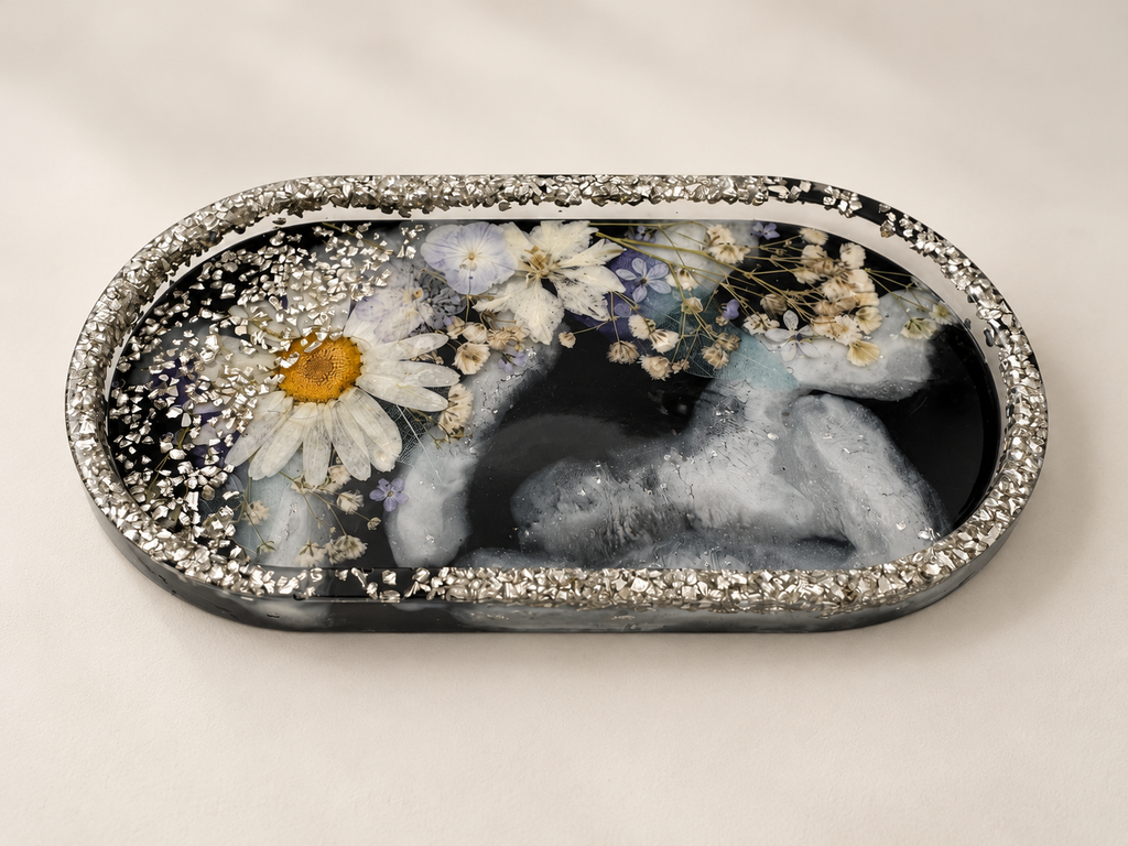 Angled view of a charcoal-and-white resin jewellery tray with real pressed flowers and silver-coloured rim details, handmade in Lancashire UK by Held Forever Studio