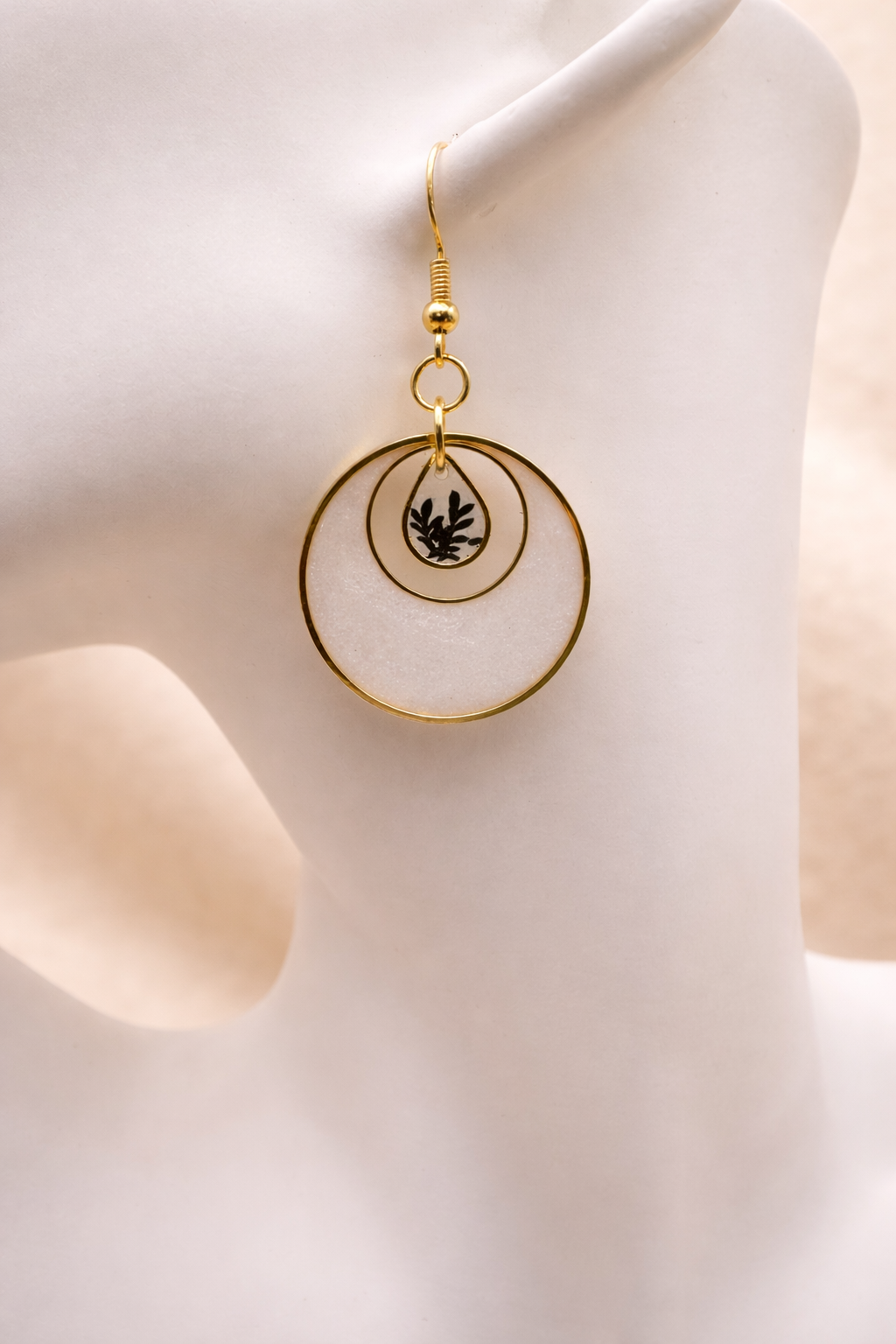 Close-up of pearl resin hoop earring with pressed botanical teardrop centrepiece, handmade in Lancashire UK