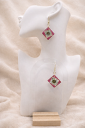 Pink resin diamond drop earring with real pressed daisy and gold foil detail on display stand, handmade by Held Forever Studio