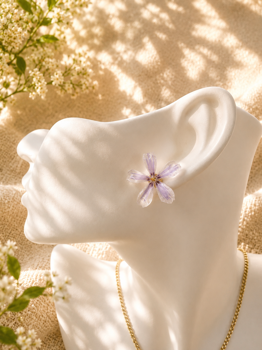 Lilac pressed flower stud earrings and necklace displayed together on a stand, real flowers set in UV resin, handmade in Lancashire UK