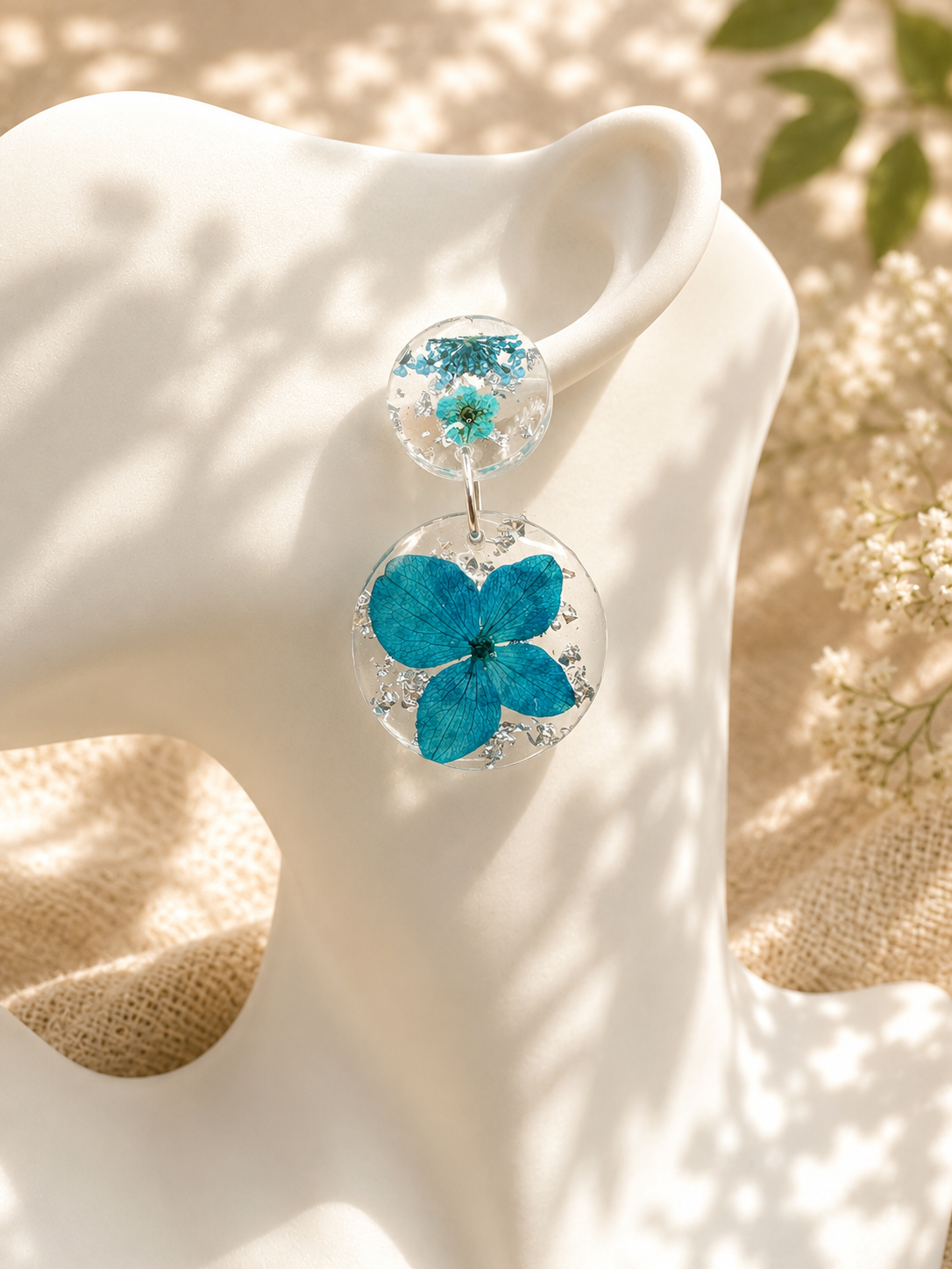 Close up of blue hydrangea resin drop earrings showing pressed botanical detail, handmade by Held Forever Studio