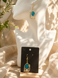 Blue botanical resin drop earring in ornate gold filigree cage frame, displayed on sculptural white bust — handmade by Held Forever Studio