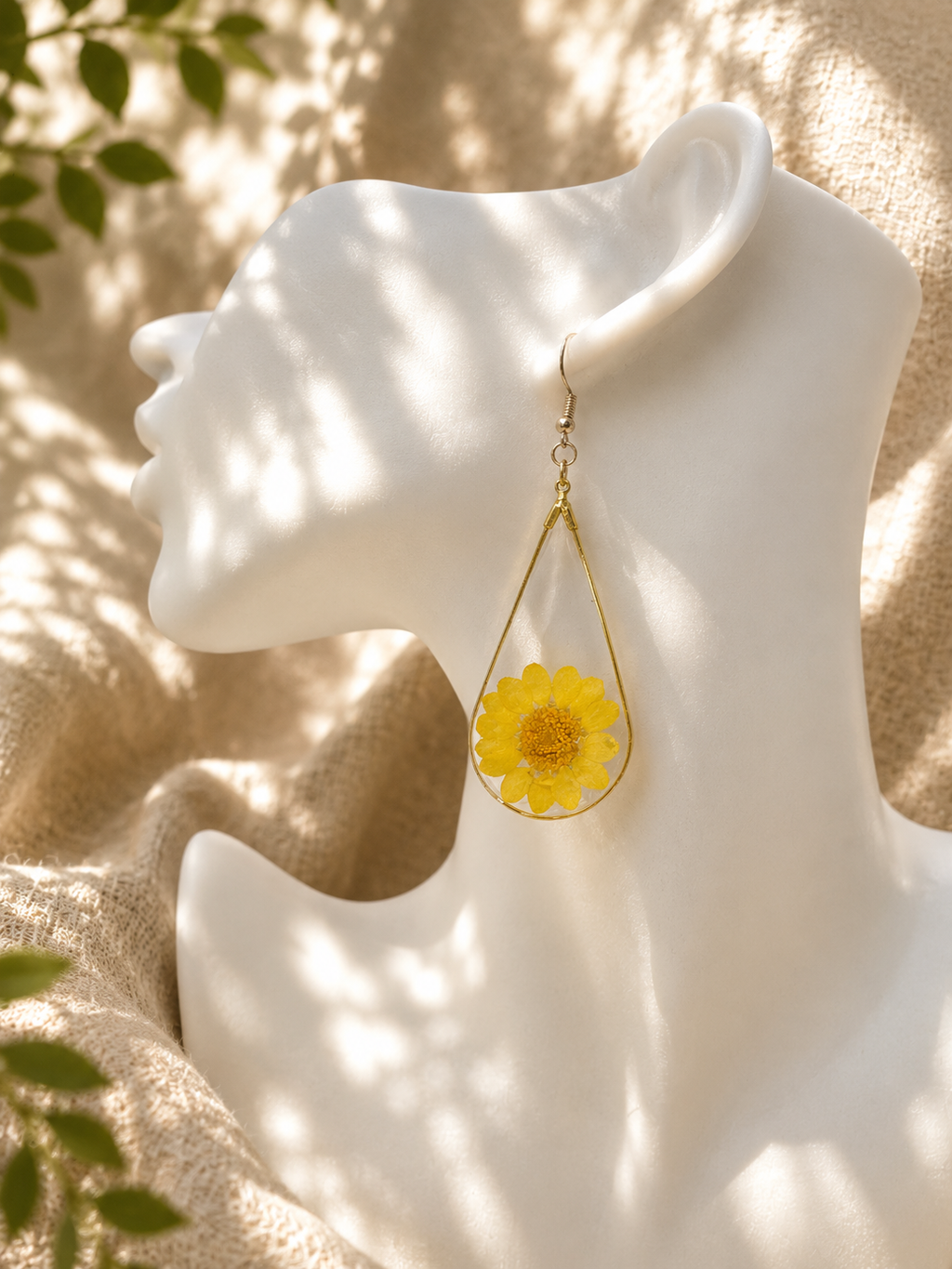 Close up of yellow pressed flower resin teardrop earring showing real botanical detail, handmade in Lancashire UK