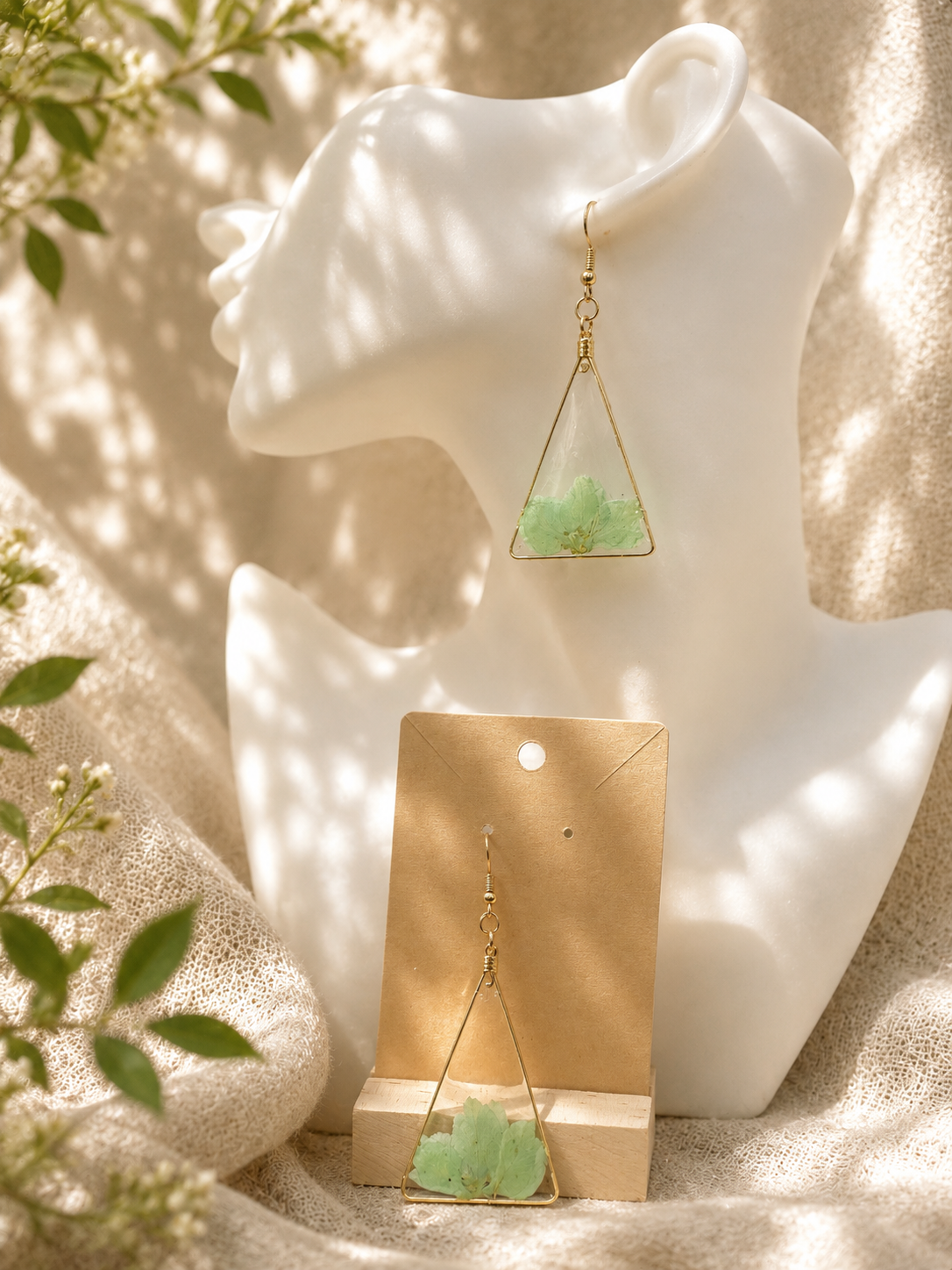 Pressed green flower triangle resin drop earrings with gold wire frame on display card and bust, handmade by Held Forever Studio