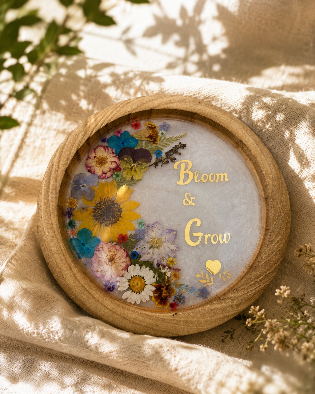 Pressed flower resin tray in wood frame reading Bloom and Grow with gold foil lettering, handmade by Held Forever Studio