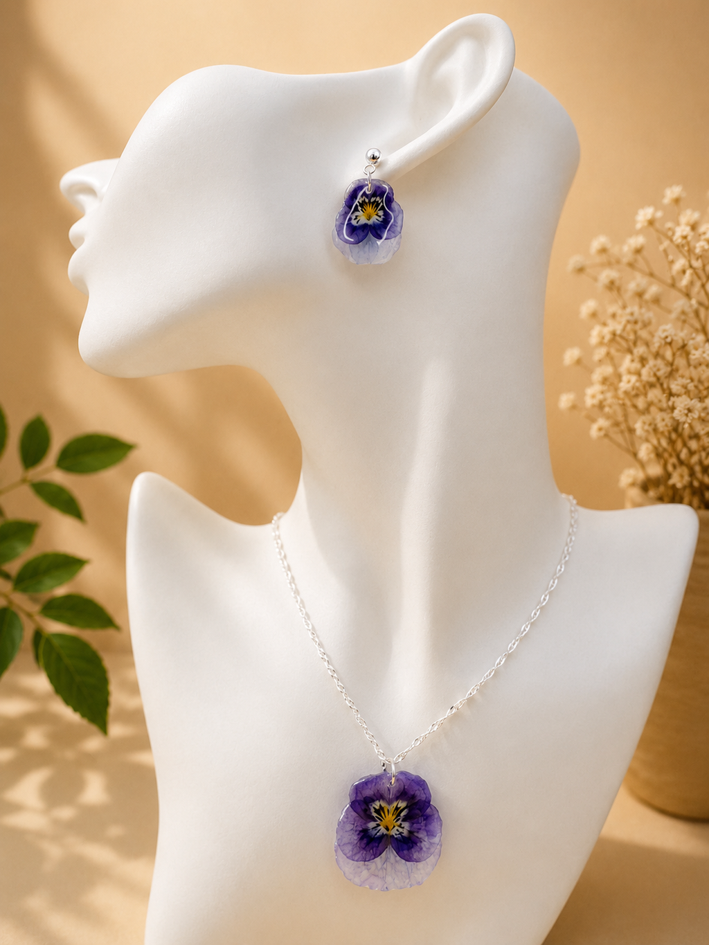 Close up of pansy resin drop earring with 925 sterling silver hook, handmade in Lancashire UK