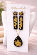 Black resin botanical jewellery set with pressed pansy earrings and teardrop necklace displayed on Held Forever Studio presentation card, handmade in Lancashire UK