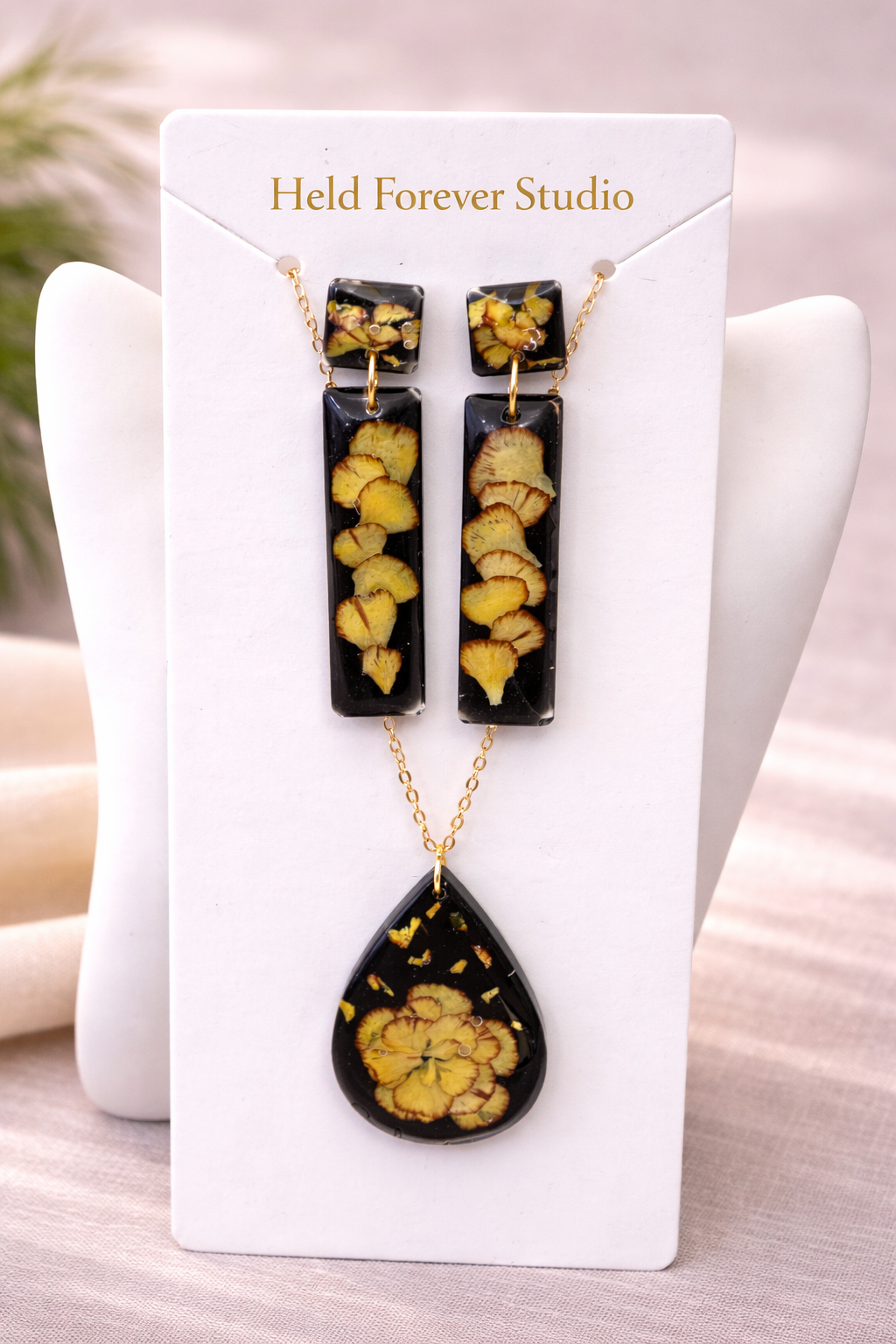Black resin botanical jewellery set with pressed pansy earrings and teardrop necklace displayed on Held Forever Studio presentation card, handmade in Lancashire UK