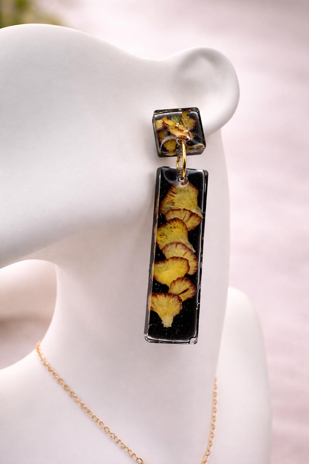 Black UV resin drop earrings with real pressed pansies worn on jewellery mannequin, handmade by Held Forever Studio