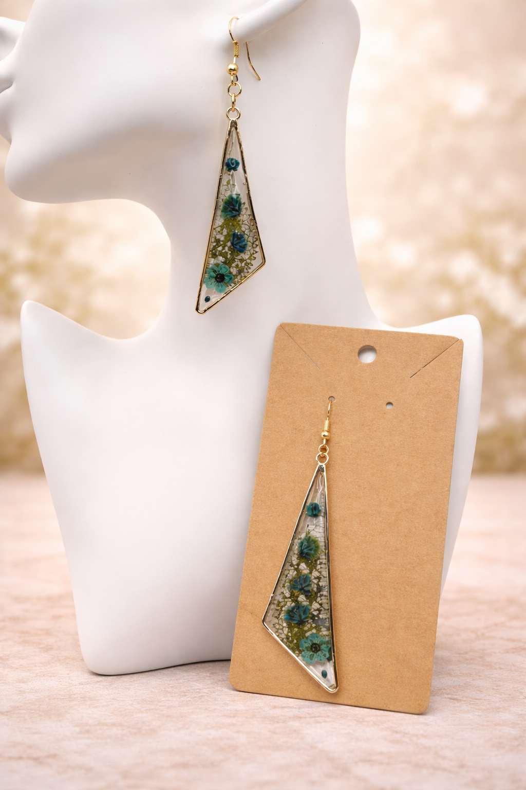 Close up of blue pressed flower resin drop earring showing real pressed forget-me-nots, cornflower and white gypsophila in clear resin, handmade by Held Forever Studio
