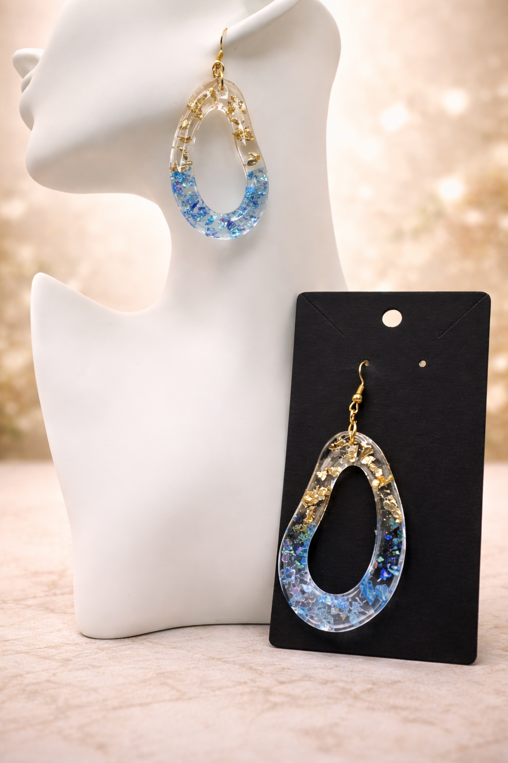 Detail of gold leaf and blue iridescent glitter in clear resin teardrop earring, handmade by Held Forever Studio