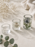 Clear resin tealight holder with real dandelion seeds and lit candle, part of a botanical set of 3 handmade in Lancashire UK by Held Forever Studio