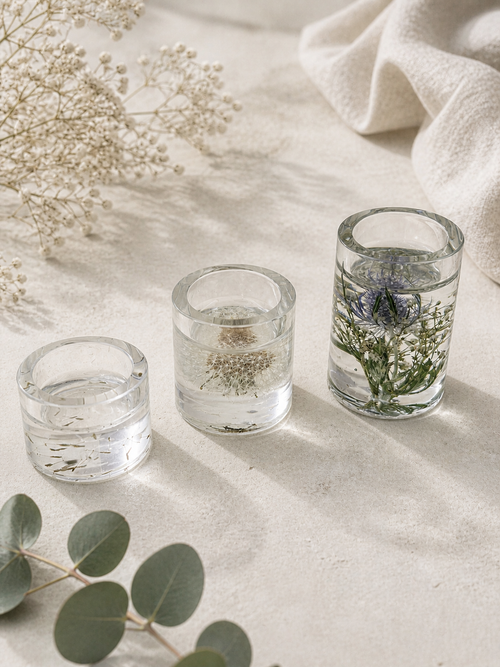 Clear resin tealight holder with real dandelion seeds and lit candle, part of a botanical set of 3 handmade in Lancashire UK by Held Forever Studio