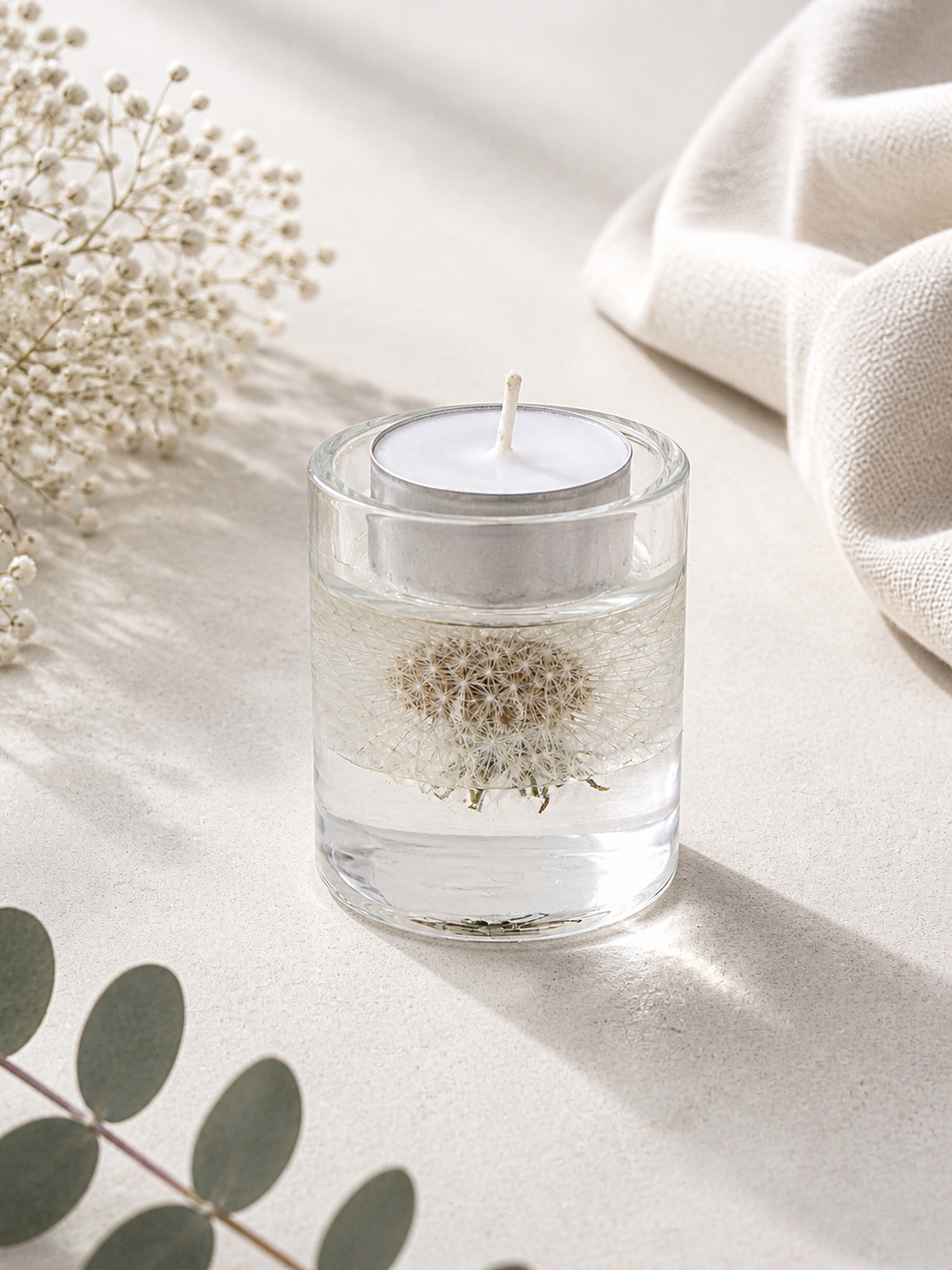 Botanical resin tealight holder set of 3 with tealight candles lit, showing dandelion and eryngium inclusions, handmade in Lancashire UK by Held Forever Studio