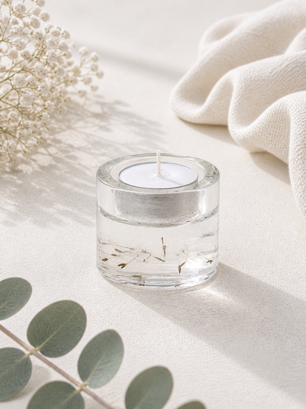Close up of tall clear resin tealight holder with real eryngium and gypsophila, handmade by Held Forever Studio in Lancashire UK