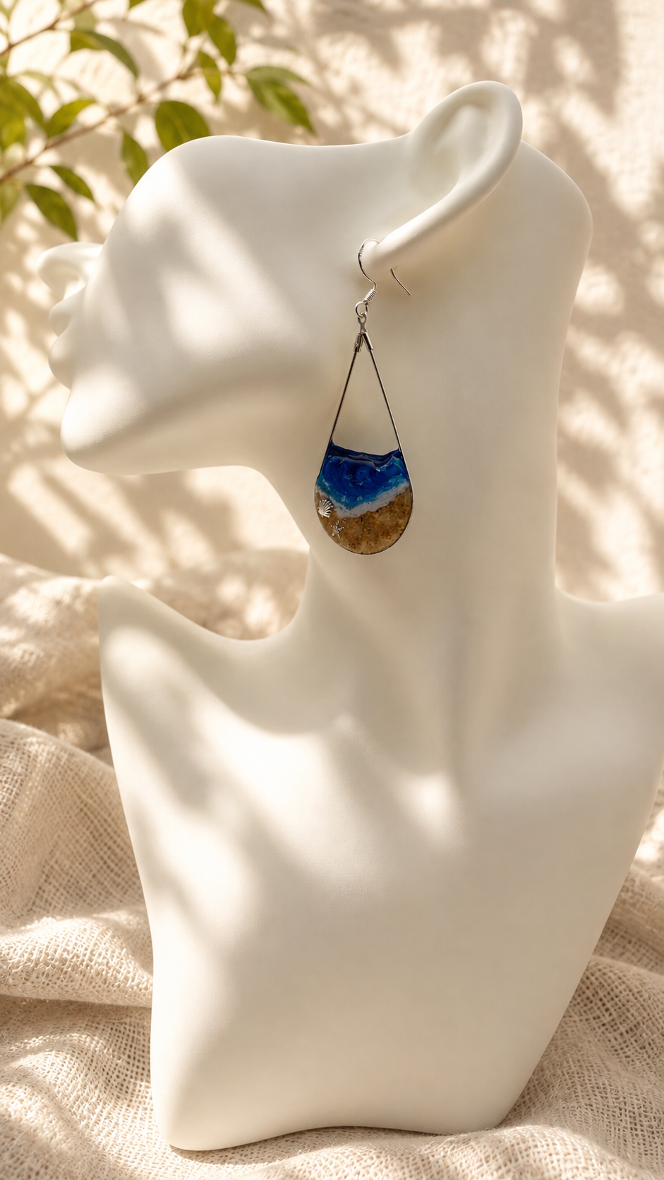 Close up of ocean wave resin drop earring showing layered blue and white resin and silver starfish charm detail, handmade by Held Forever Studio