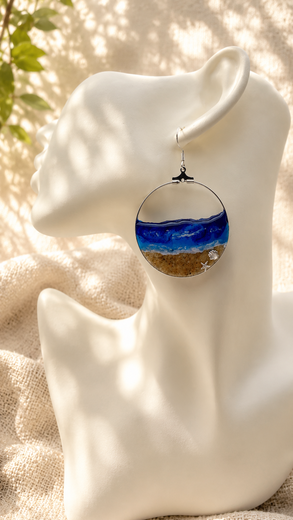 Close up of ocean wave resin hoop earring showing layered blue and white resin and silver shell charm detail, handmade by Held Forever Studio