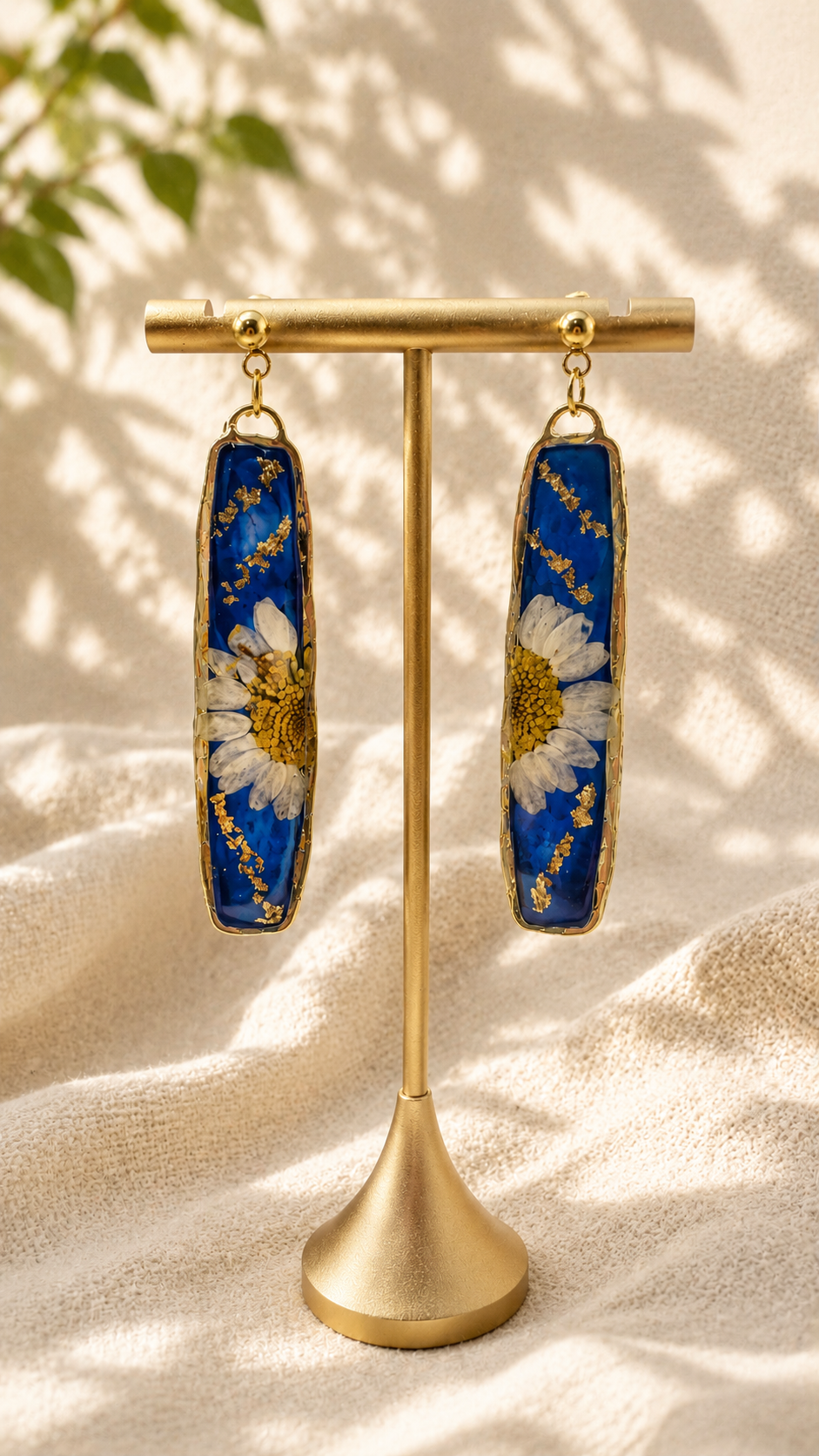 Navy resin bar drop earrings with a real pressed daisy, gold leaf detailing and 24k gold-plated stud tops, handmade by Held Forever Studio