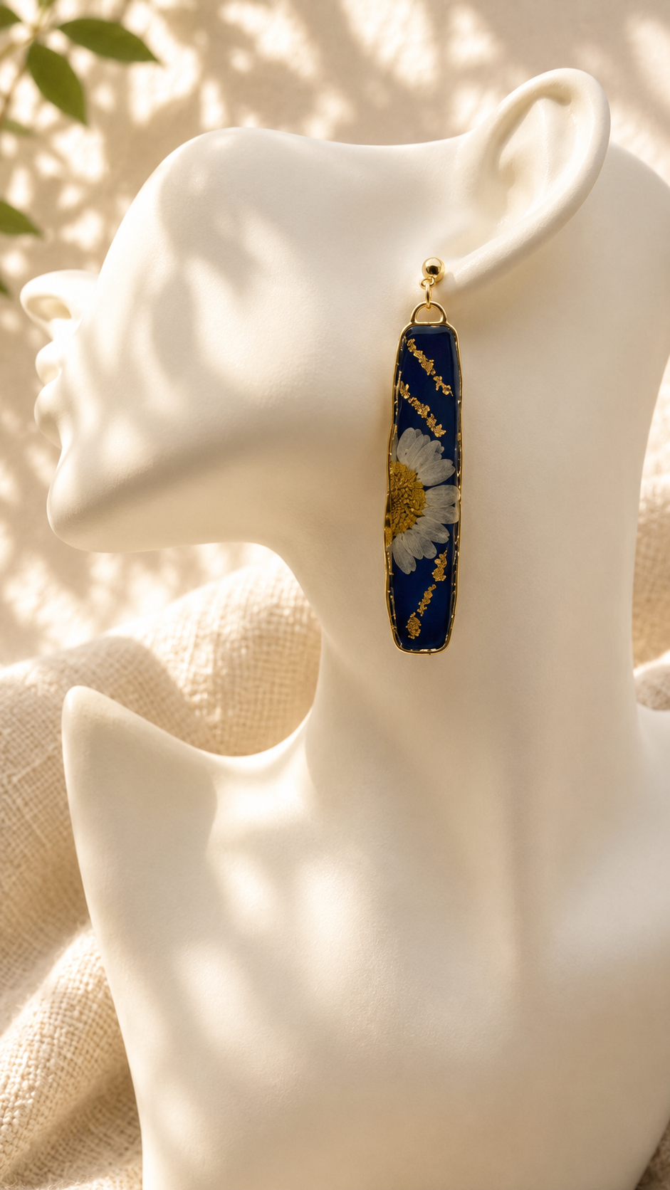 Pair of pressed daisy resin bar drop earrings on a gold stand, handmade in Lancashire UK