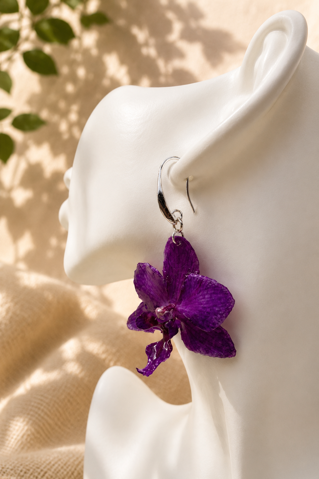 Close up of real orchid bloom preserved in resin, sterling silver drop earring, handmade by Held Forever Studio
