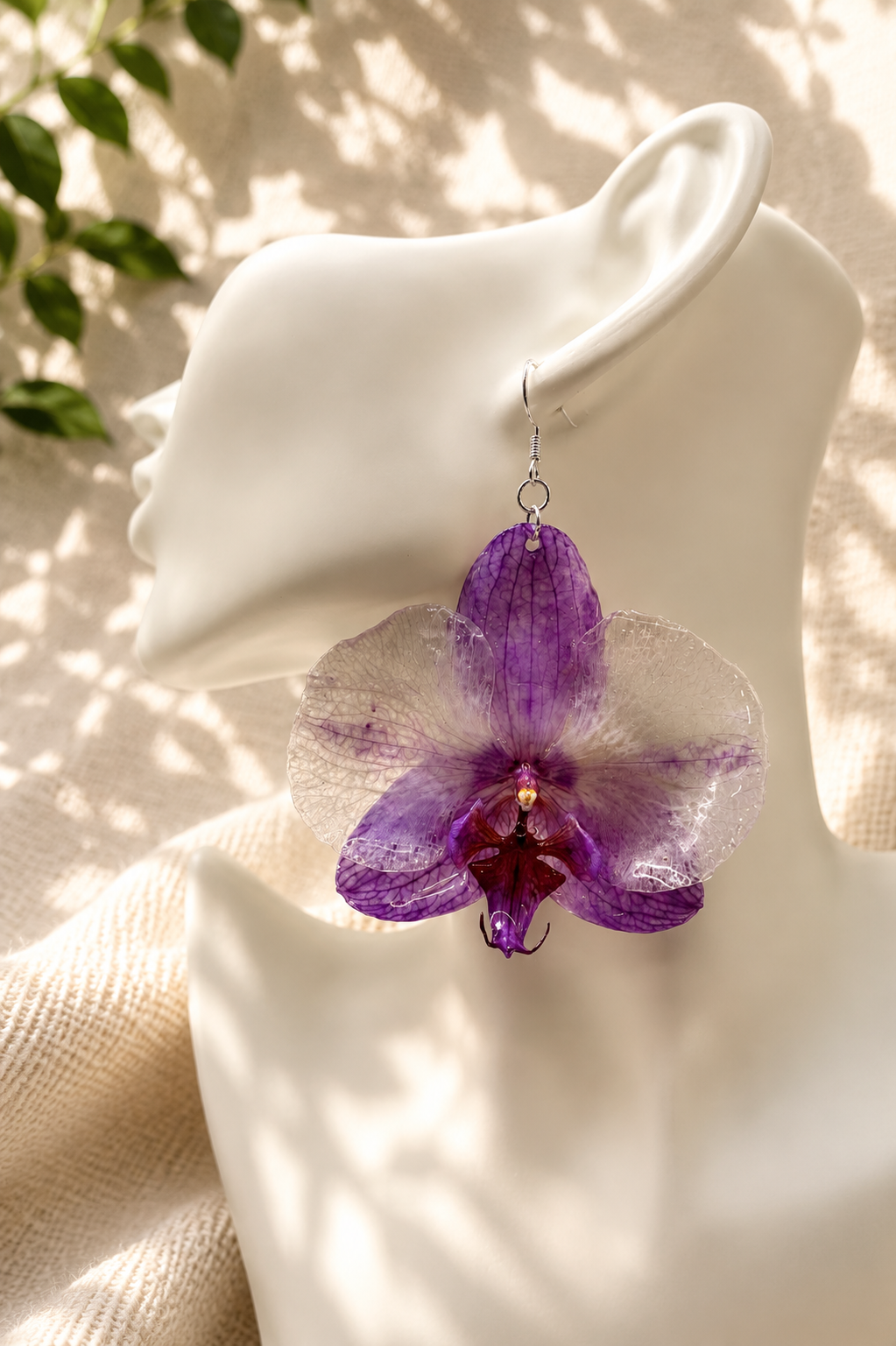 Close up of purple orchid resin drop earring showing preserved petal detail, handmade by Held Forever Studio