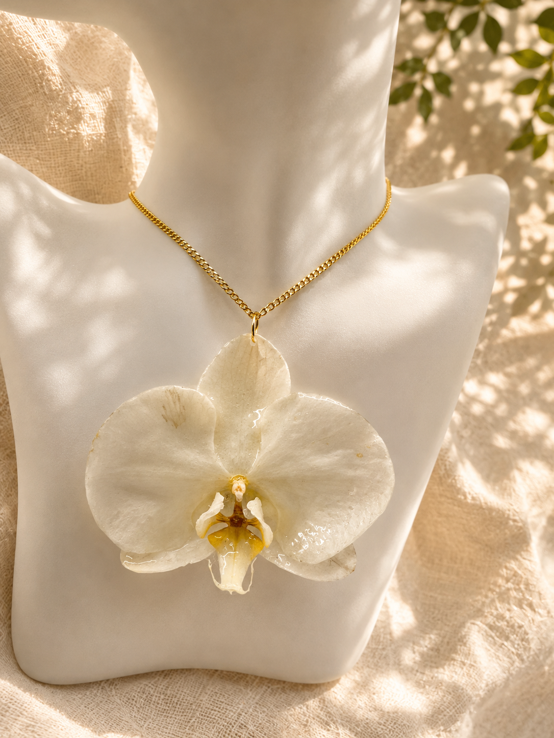Close up of the white orchid bloom preserved in resin in the pendant necklace, handmade in Lancashire UK