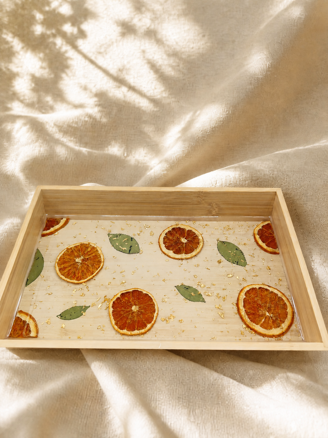 Citrus resin serving tray in a bamboo frame with real dried orange slices and gold flake, handmade by Held Forever Studio