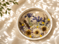 Round pressed wildflower resin tray with iris, daisies, and buttercups, handmade by Held Forever Studio