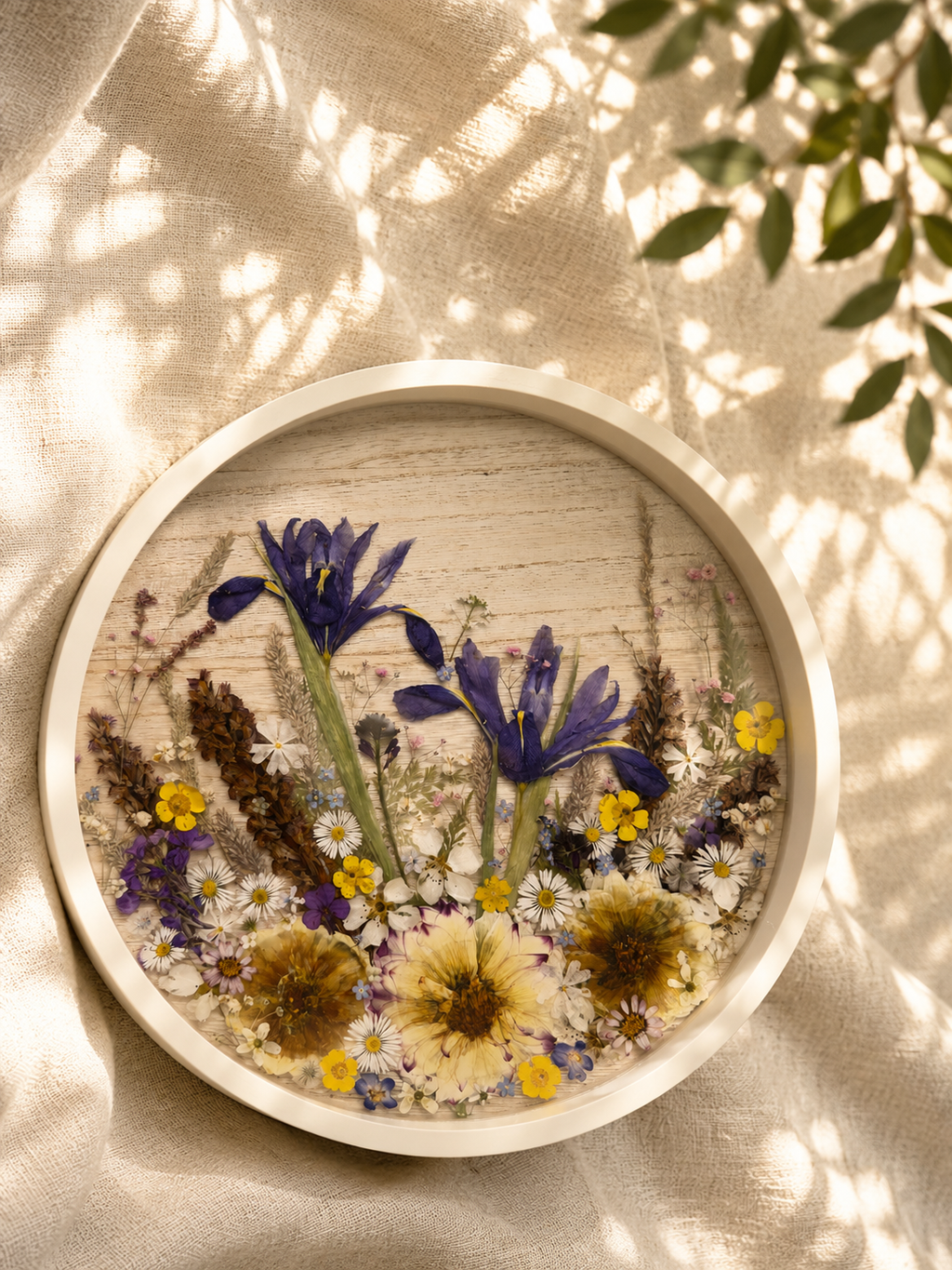 Detail of pressed daisies and forget-me-nots in the round resin tray, handmade by Held Forever Studio