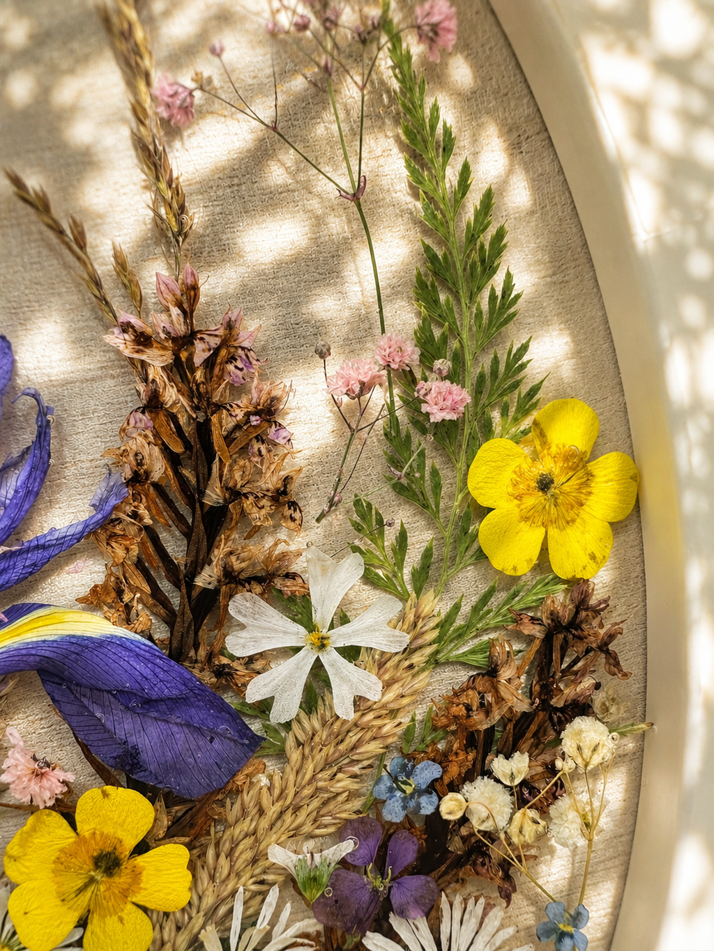 Top view of the round pressed wildflower resin tray on natural linen, handmade in Lancashire UK