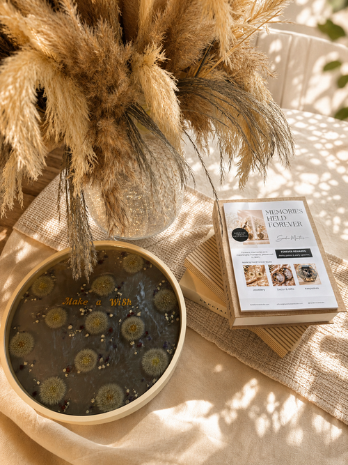 Close up of the dandelion resin tray showing pressed seed heads and gold lettering, handmade in Lancashire UK