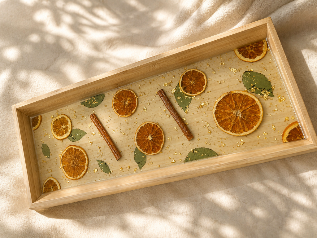 Detail of the dried orange slices, cinnamon sticks and gold flake set in resin in the long tray, handmade by Held Forever Studio