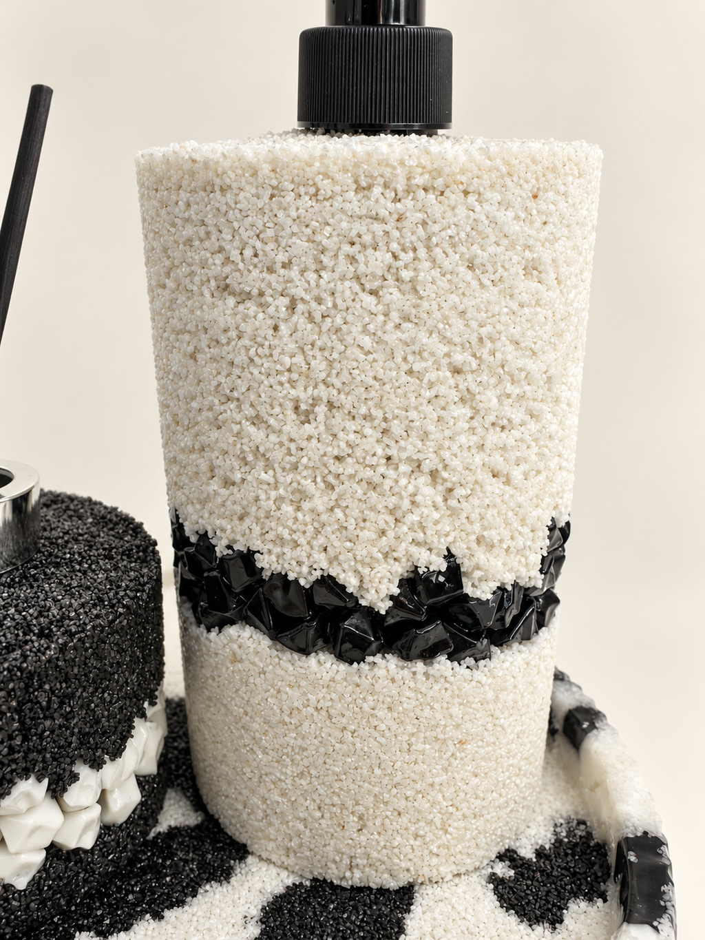 White sand-textured soap dispenser with a black stone band and black pump, hand-decorated in Lancashire UK by Held Forever Studio