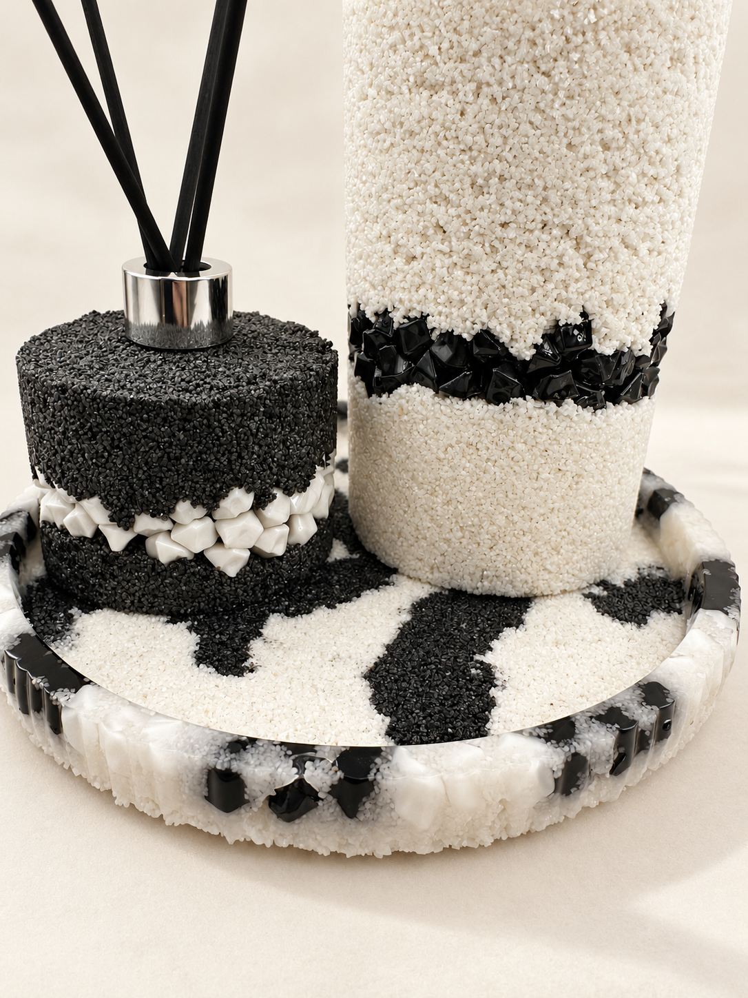 Close view of monochrome decorated bottles and coordinating resin tray with contrasting stones and sand, handmade in Lancashire UK by Held Forever Studio