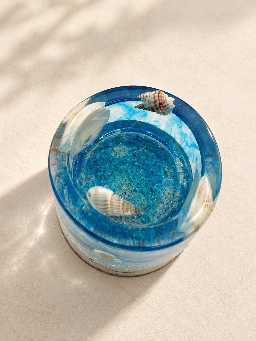 Top view of an ocean-blue resin candle holder showing shell details and a textured base, handmade in Lancashire UK by Held Forever Studio