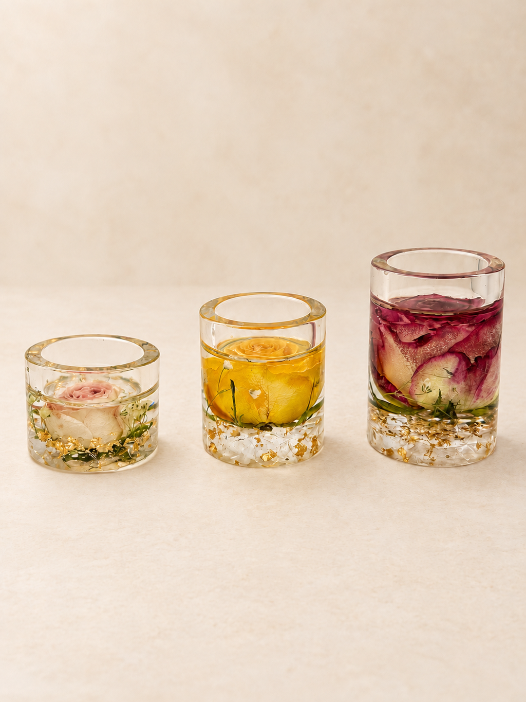 Set of three clear resin candle holders with real blush, yellow and burgundy roses and gold-coloured details, handmade in Lancashire UK by Held Forever Studio