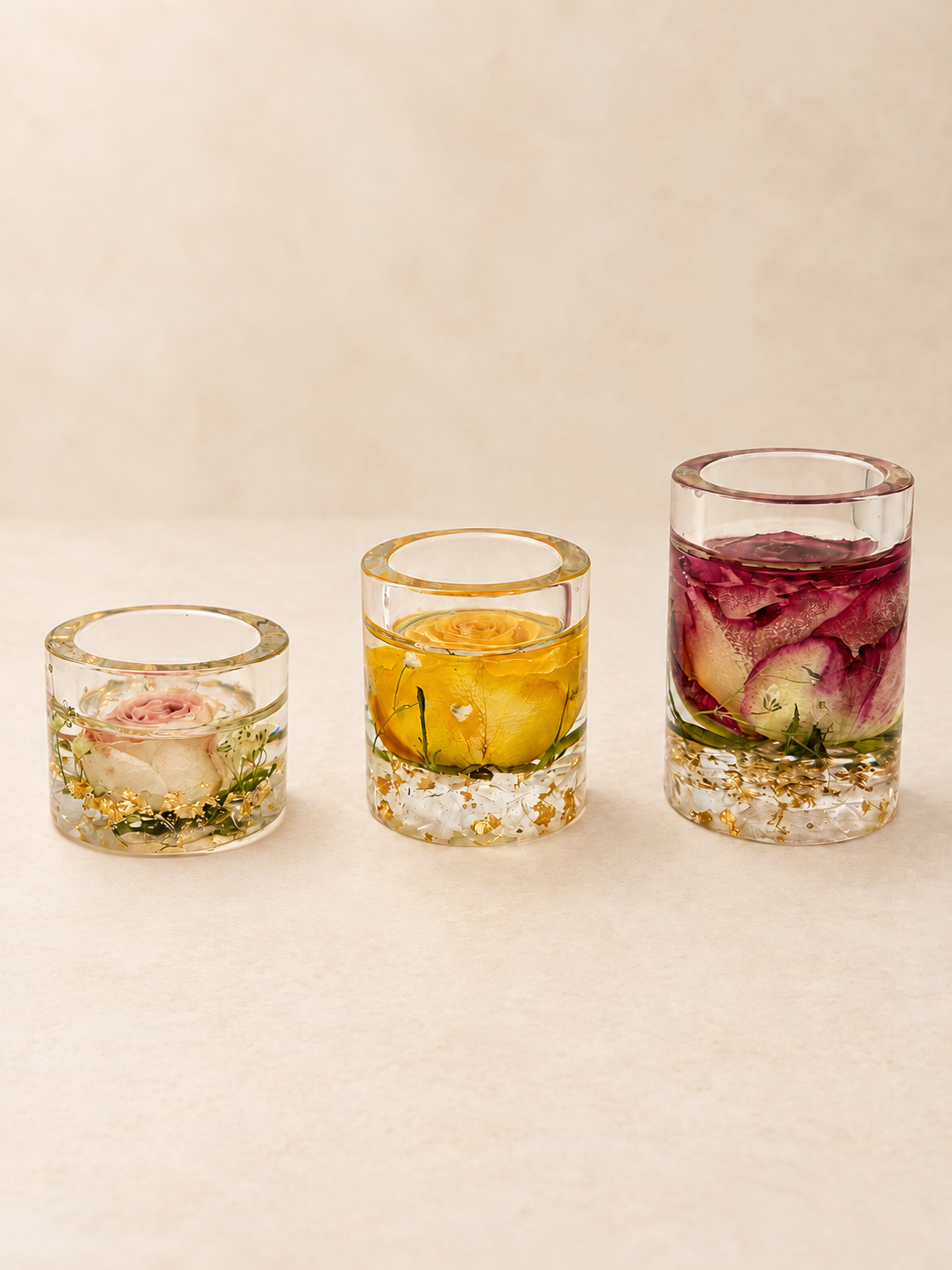 Set of three clear resin candle holders with real blush, yellow and burgundy roses and gold-coloured details, handmade in Lancashire UK by Held Forever Studio